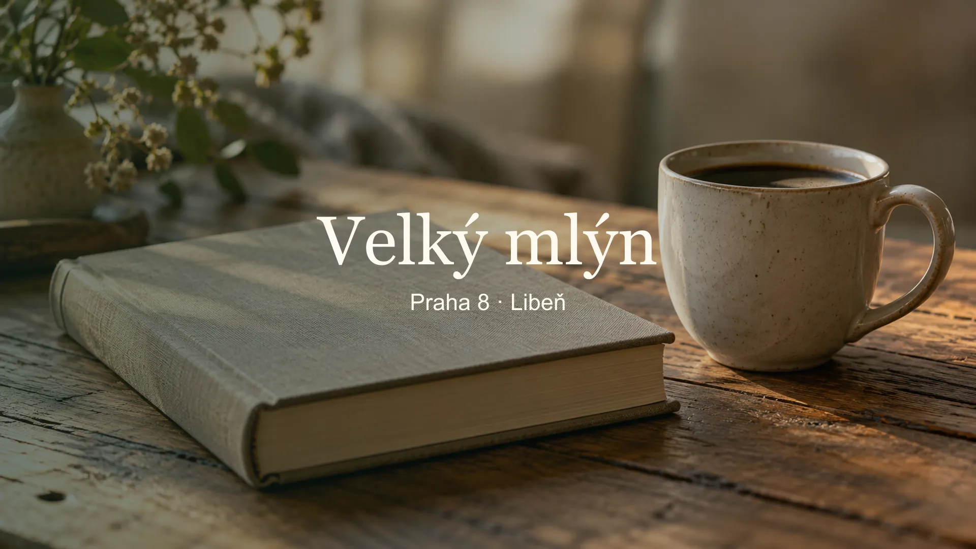 Zátiší s knihou a šálkem kávy, titulek Knihovna Velký mlýn v Libni, Praha 8 · Libeň